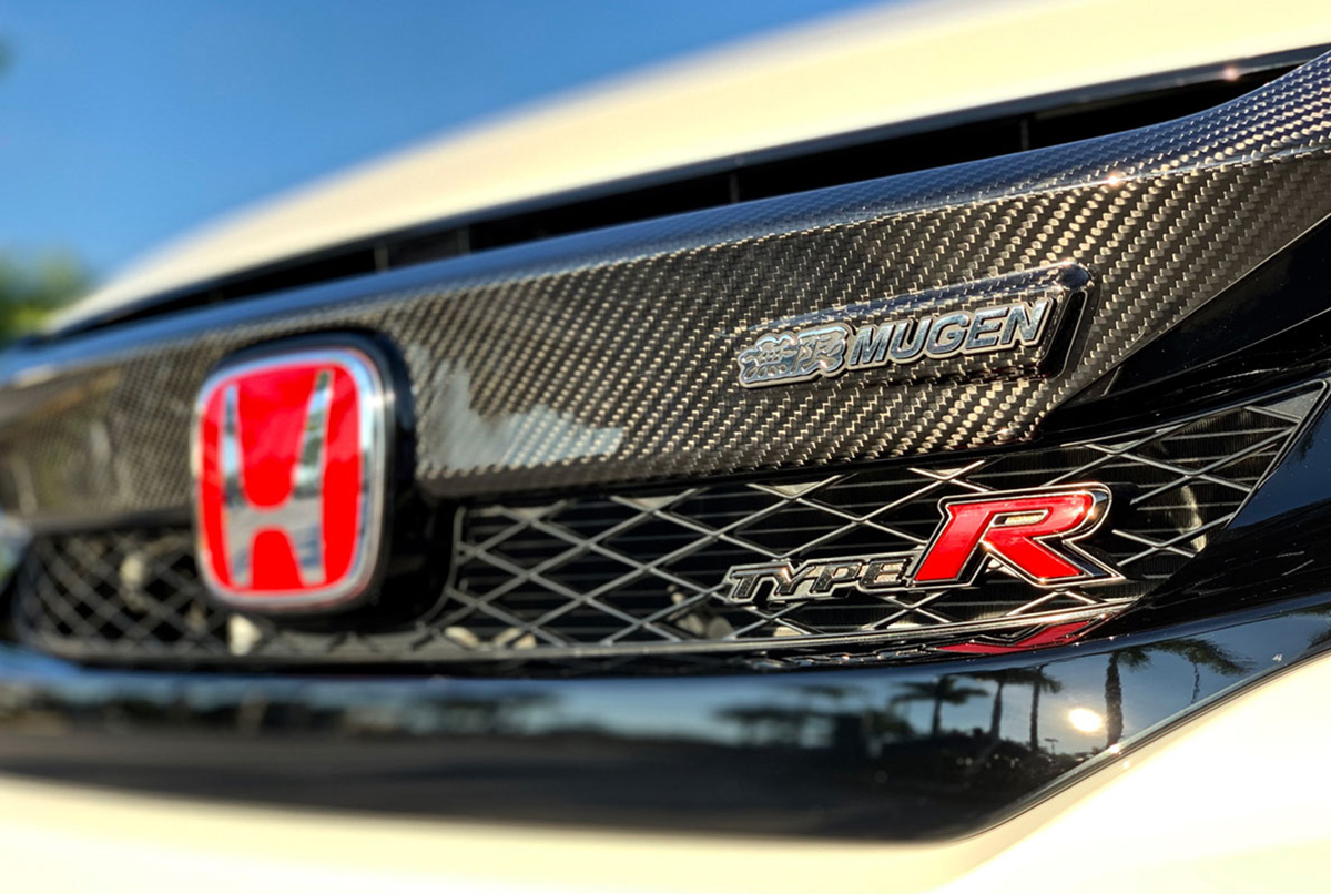 Mugen 10th Gen Civic Carbon Fiber Front Grill Garnish - Enhance the style of your Civic with Mugen's carbon fiber garnish. Fits 2016-2021 Civic models and 2017-2021 FK8 Civic Type R. Limited stock available.